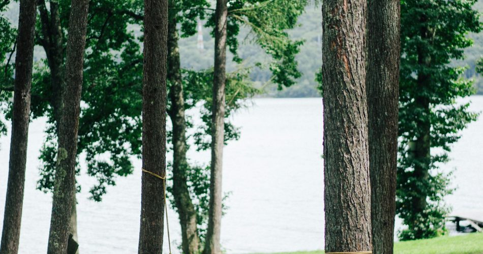 Green hammock tied between trees near water - outdoor relaxation in Nepali nature