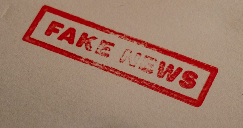 Red stamp reading fake news on document - honest business and integrity concept
