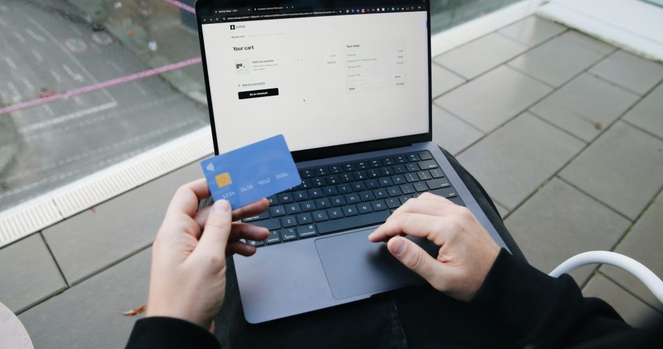 Person holding credit card and laptop representing digital finance and online lending